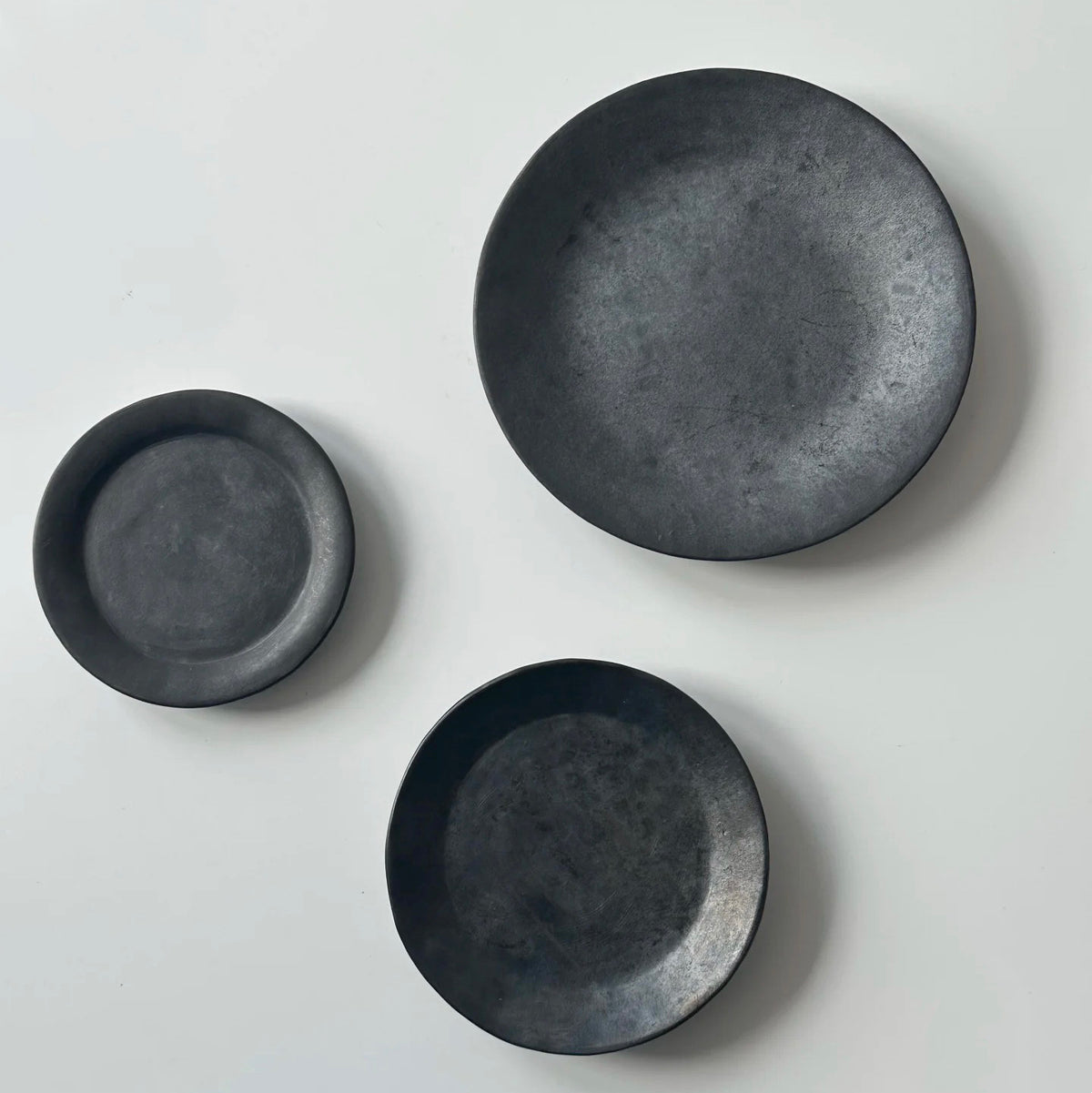How many black pottery flat plates and cake plates (large, medium, small)