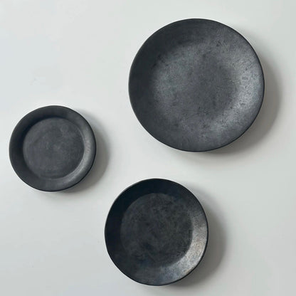 How many black pottery flat plates and cake plates (large, medium, small)