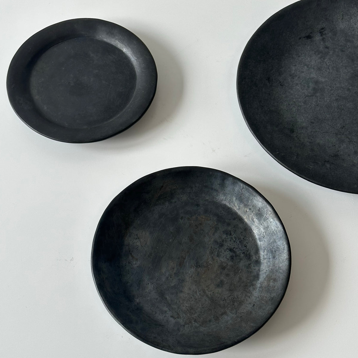 How many black pottery flat plates and cake plates (large, medium, small)